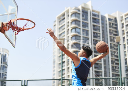 young asian adult dunking basketball on outdoor court young asian adult dunking basketball on outdoor court 93532024