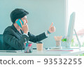 Business man showing ok thumb up gesture while talking on mobile phone in the office. 93532255