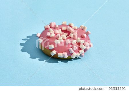 Food design. Close up high quality image of pink glazed donut on blue background 93533291
