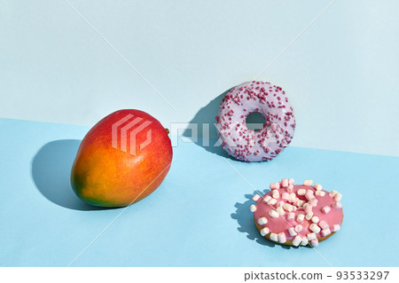 Composition of fresh fruits and sweets, two donuts and juicy mango 93533297