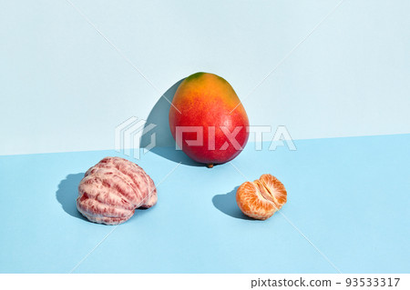 Composition of fresh fruits, mango and mandarin, half of peeled mandarin and mango 93533317