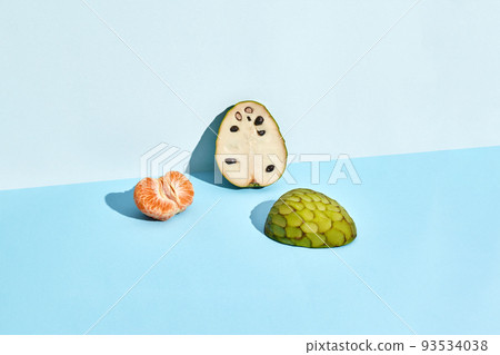 Half of sugar-apple, fruit of Annona squamosa cherimoya and mandarin 93534038