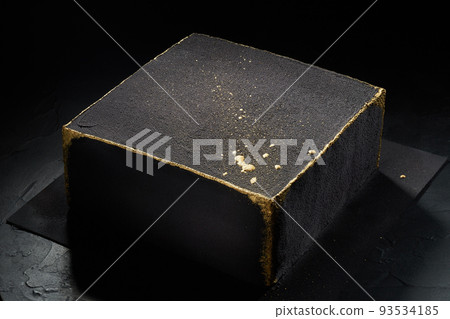 Black square cake with gold edges. Dark background. The view from the top. Black square cake with gold edges. Dark background. The view from the top. 93534185