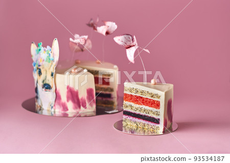 Pastel colors tasty cake with butterflies and little deer. Pink background. Selective focus. Pastel colors tasty cake with butterflies and little deer. Pink background. Selective focus. 93534187
