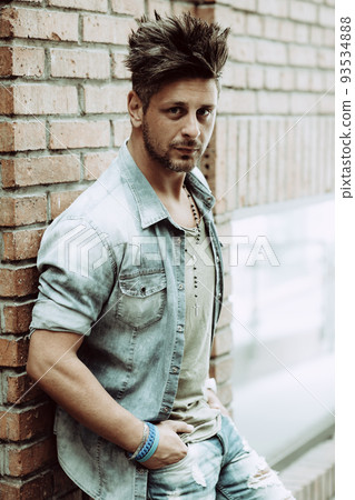 Portrait of handsome man in casual clothing posing on the street, looking away to a side. Color Toned Image. Concept urban man. 93534888