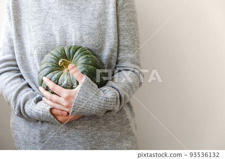 Autumnal Background. Unrecognizable woman hand holding in hands autumn fall pumpkin isolated on white background. Change of seasons ripe organic food, Halloween party Thanksgiving day Autumnal Background. Unrecognizable woman hand holding in hands autumn fall pumpkin isolated on white background. Change of seasons ripe organic food, Halloween party Thanksgiving day 93536132