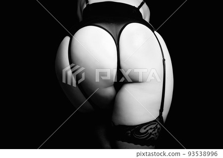 Female hips with black sexy garter belt, fishnet stockings and black panties. Close up view, isolated on black. Concept femme fatale 93538996