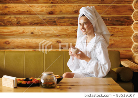 Pretty girl with a cup of tea after sauna Pretty girl with a cup of tea after sauna 93539107