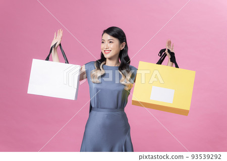 Beautiful young woman with shopping bags on color background 93539292
