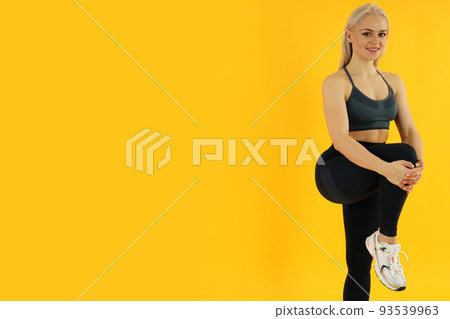Concept of healthy lifestyle with sporty woman on yellow background Concept of healthy lifestyle with sporty woman on yellow background 93539963