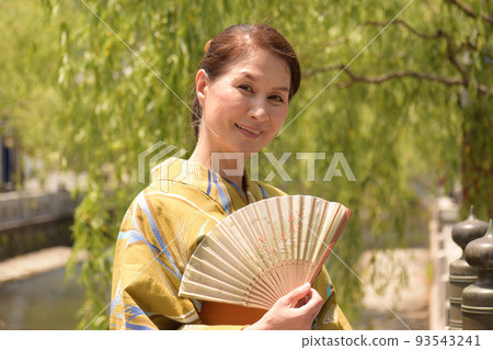 一位身著浴衣在溫泉街閒逛的資深女士 一位身著浴衣在溫泉街閒逛的資深女士 93543241
