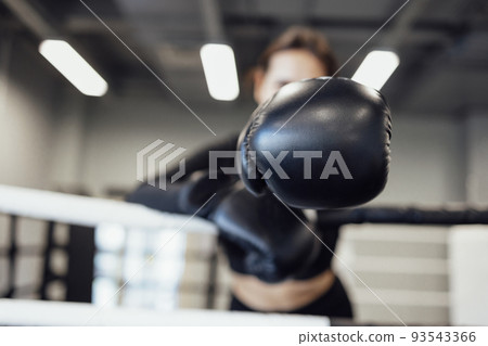 Strong latin boxing woman on the ring at fitness gym. Athletic girl training Muay Thai boxing for bodybuilding Strong latin boxing woman on the ring at fitness gym. Athletic girl training Muay Thai boxing for bodybuilding 93543366