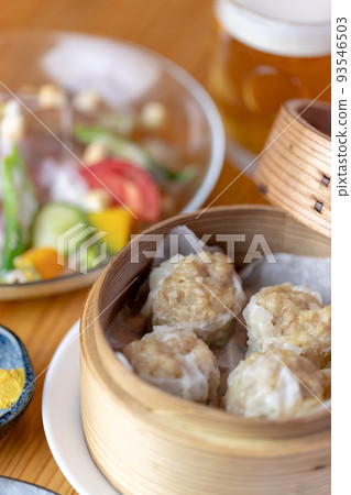 Shumai, Caesar salad and draft beer 93546503