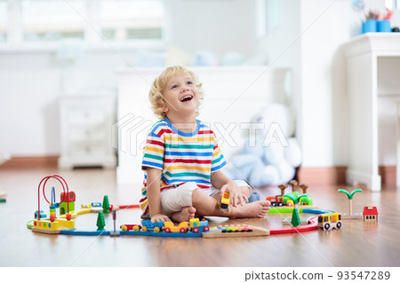 Kids play wooden railway. Child with toy train. Kids play wooden railway. Child with toy train. 93547289