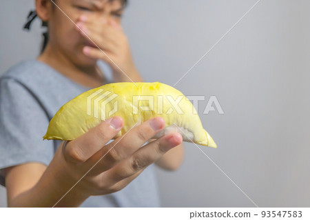 Close-up of 1 ripe durian. Ready to eat., The foul smell of durian makes this woman dislike eating durian, This woman doesn't like the foul smell of durian. 93547583