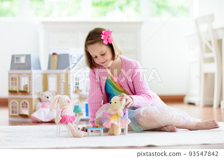 Little girl playing with doll house. Kid with toys 93547842
