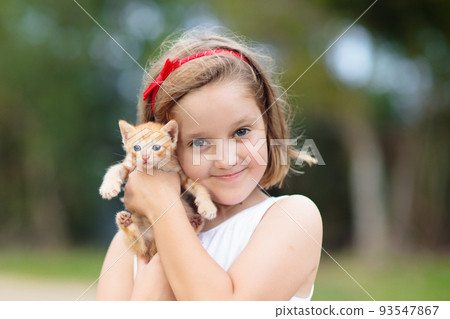 Little girl holding baby cat. Kids and pets 93547867