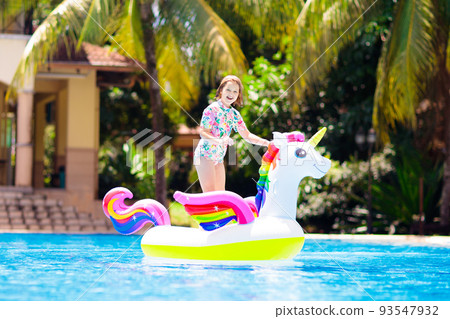 Child on unicorn float in swimming pool. Kids swim Child on unicorn float in swimming pool. Kids swim 93547932