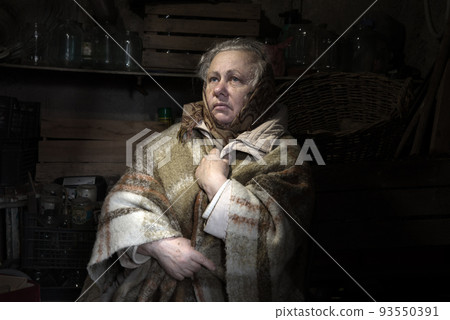 Frightened woman hide from explosions in the basement. During the sirens due to the shelling of Kyiv. Ukraine. 26 February 2022 93550391