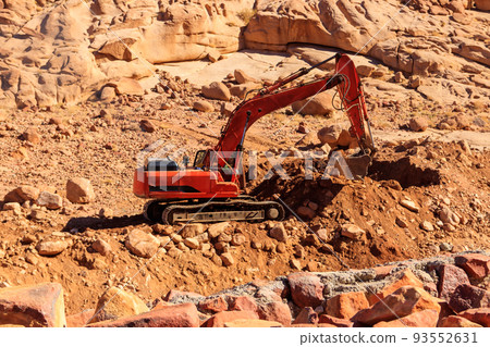 Orange excavator working at construction site in desert in Sinai peninsula, Egypt Orange excavator working at construction site in desert in Sinai peninsula, Egypt 93552631