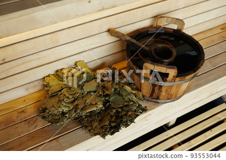 Sauna bucket full of water with ladle and broom on the wooden bench Sauna bucket full of water with ladle and broom on the wooden bench 93553044