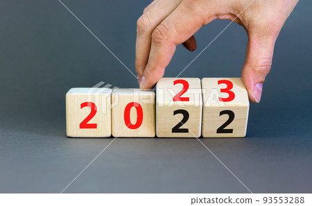 2023 happy new year symbol. Businessman turns cubes, symbolize the change from 2022 to the new year 2023. Beautiful grey background. Copy space. Business and 2023 happy new year concept. 93553288