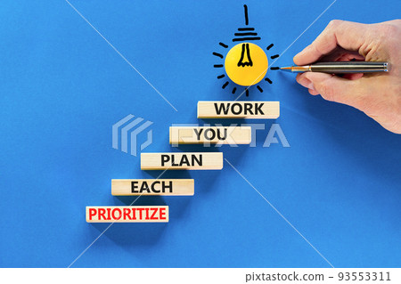 Prioritize each plan you work symbol. Concept words Prioritize each plan you work on blocks on beautiful blue background. Businessman hand. Business prioritize each plan you work concept. Copy space 93553311