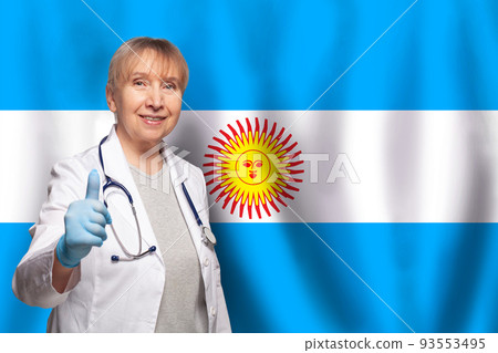 Argentine smiling mature doctor woman holding stethoscope on flag of Argentina background 93553495