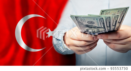 National Turkish flag and US dollars in hands. Business, tax, banking and finance concept 93553730