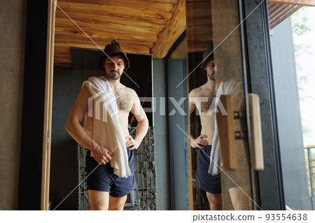 Muscular man in the sauna with a towel on his shoulders 93554638
