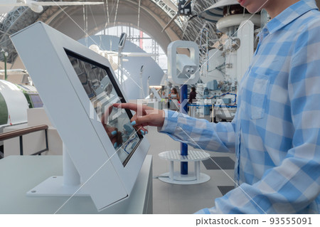 Woman touching interactive touchscreen display kiosk at exhibition: close up Woman touching interactive touchscreen display kiosk at exhibition: close up 93555091