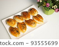 freshly baked assorted rolls with a stuffing in a white plate on the table. 93555699
