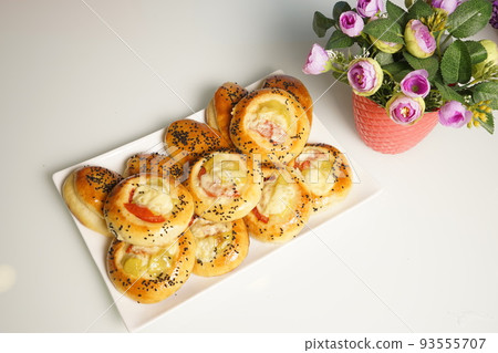 freshly baked assorted rolls with a stuffing in a white plate on the table. freshly baked assorted rolls with a stuffing in a white plate on the table. 93555707