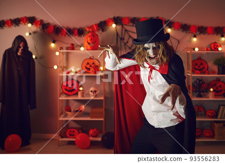 Portrait of an adult man dressed up in a spooky Halloween costume of an evil vampire 93556283