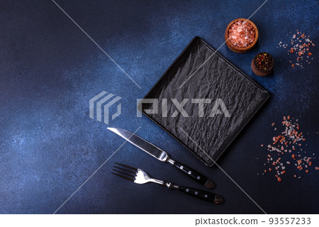 Empty square black plate on dark moody background with copy space Empty square black plate on dark moody background with copy space 93557233