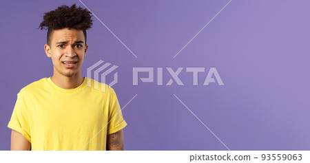 Close-up portrait of awkward and embarrassed young hispanic guy looking nervous, meeting girlfriend parents, stare scared and with panic, feeling concerned, cringe over purple background 93559063