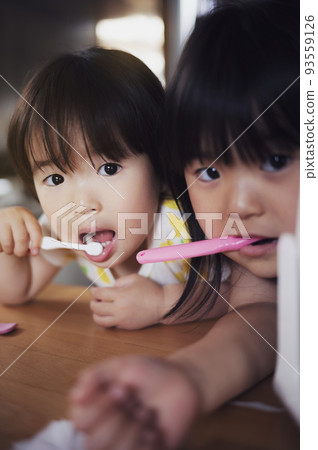 2-year-old and 5-year-old girls who brush their teeth by themselves 2-year-old and 5-year-old girls who brush their teeth by themselves 93559126