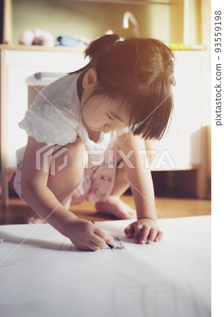 Child drawing and playing with crayons 93559198