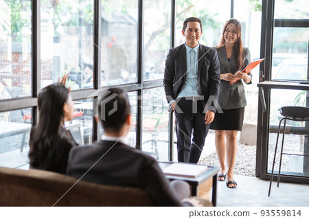 worker while meeting in cafe with partner and assistant worker while meeting in cafe with partner and assistant 93559814