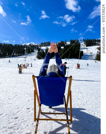 Shot of a skier woman sitting on the ski slope resting relaxing extreme recreation active lifestyle activity. Female skier on a slope in the mountains. Winter active sport  93559824