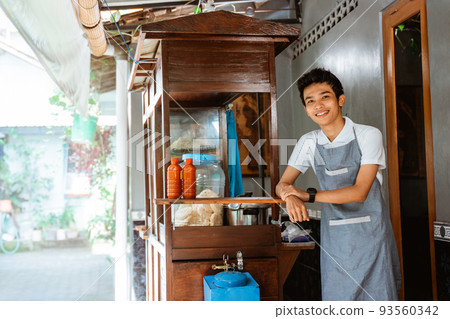 Smiling male chicken noodle seller wearing apron standing 93560342