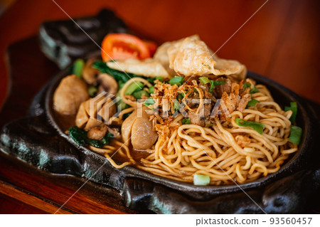fried chicken noodle dish on a hot plate 93560457
