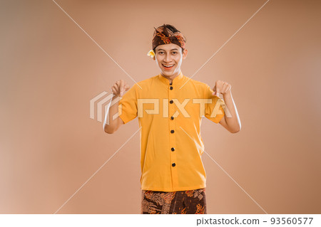 balinese young man presenting and pointing to copyspace balinese young man presenting and pointing to copyspace 93560577