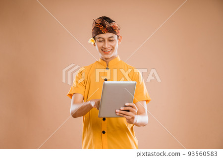 portrait of balinese young man using tablet pc 93560583