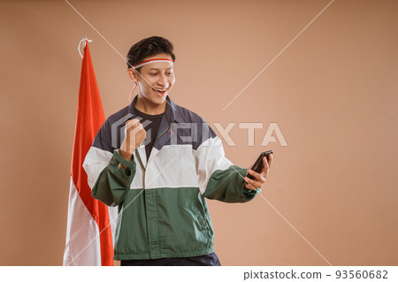 young male athelete using mobile phone over isolated background 93560682