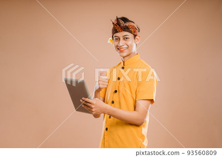 portrait of balinese young man using tablet pc portrait of balinese young man using tablet pc 93560809