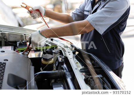 Close up and Selective focus of car mechanic holding battery electricity cables jumper for charging car battery, Services car engine machine concept Close up and Selective focus of car mechanic holding battery electricity cables jumper for charging car battery, Services car engine machine concept 93570152