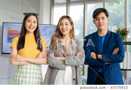 Group of Asia young entrepreneurs creative people looking at camera and smiling after brainstorming, working together in the office. Stratup business team discusses and shares ideas for new projects. 93570913
