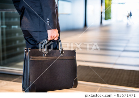 Hands of a man with a business bag 93571471