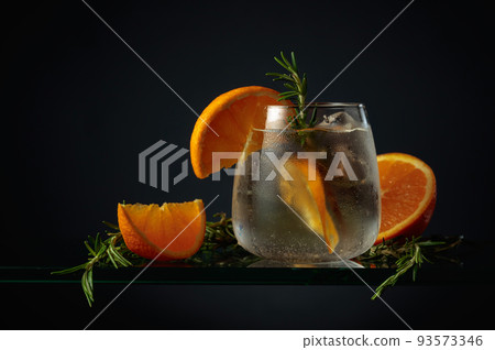 Cocktail with ice, orange, and rosemary. Cocktail with ice, orange, and rosemary. 93573346